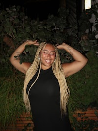 a woman wearing a black dress with dreadlocks